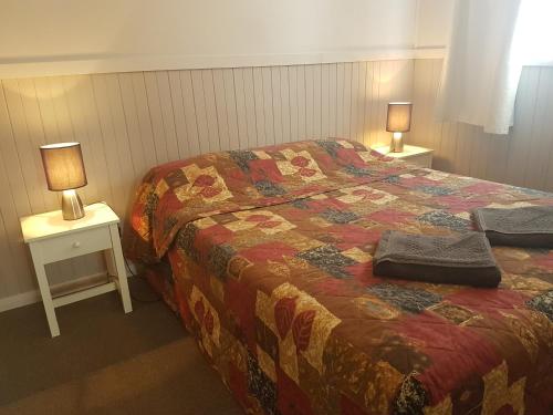 海伊BIG4 Hay的一间卧室配有一张床和两张带台灯的桌子。