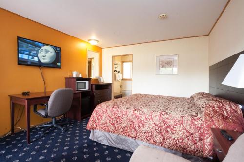 Marshfield帕克汽车旅馆的酒店客房配有一张床、一张书桌和一台电视。