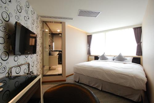 台北欣欣旅店的一间卧室配有一张床、一台电视和一间浴室。