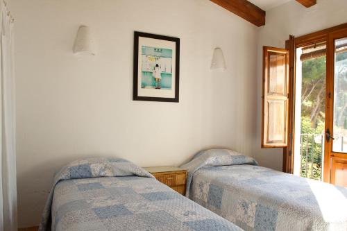 莫莱拉Moraira Beach Rental的卧室配有两张床,墙上挂着一幅画