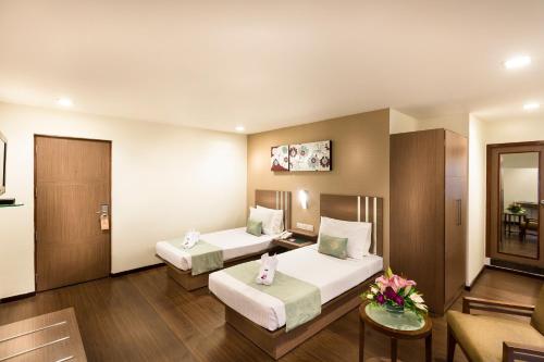 钦奈The Lotus Apartment Hotel, Venkatraman Street的酒店客房,设有两张床和一张沙发