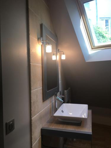 布鲁瓦Maison Joséphine avec garage privé的一间带水槽和镜子的浴室以及窗户。