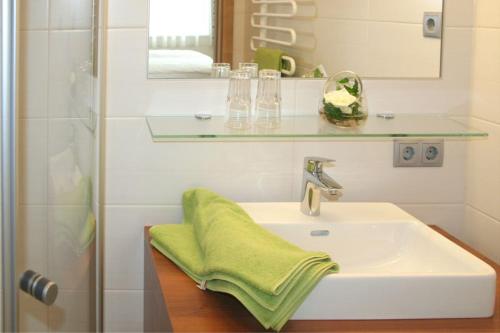 Sankt Peter am Wimberg豪厄维特宾馆 的浴室设有水槽,上面有绿毛巾