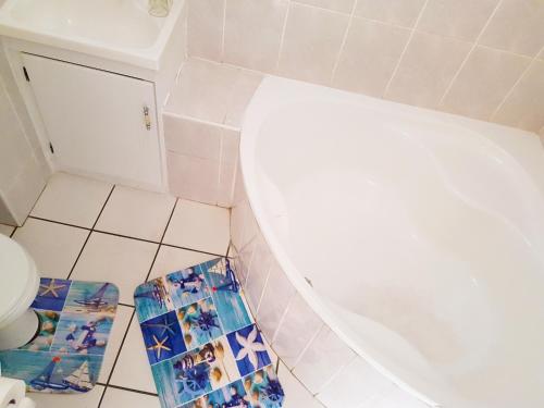 马盖特Dumela Margate Flat No 3的一间带卫生间的浴室,铺有瓷砖地板。