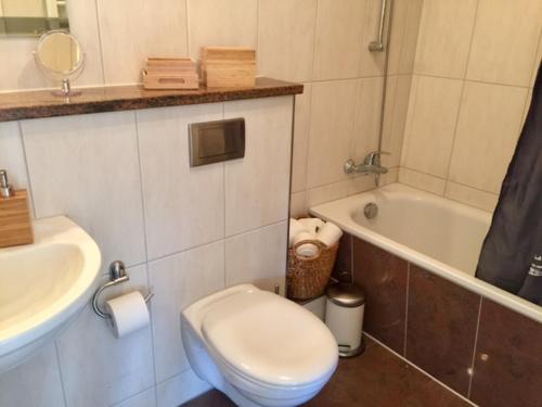 博尔滕哈根Afrika的浴室配有卫生间、盥洗盆和浴缸。