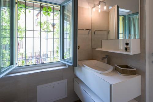 米兰Luxury Apartment Milano Centro的白色的浴室设有水槽和窗户。
