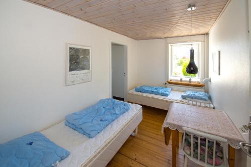 莱斯Annekset Vesterø Havn的客房设有两张床和窗户。