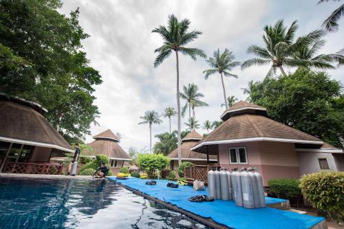 涛岛涛岛珊瑚度假酒店的一个带游泳池和棕榈树的度假村