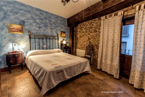 帕萨若La Antigua Botica的一间卧室设有一张床和石墙