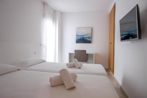 圣埃乌拉利亚Sal Mar Suites的一间卧室配有两张带毛巾的床