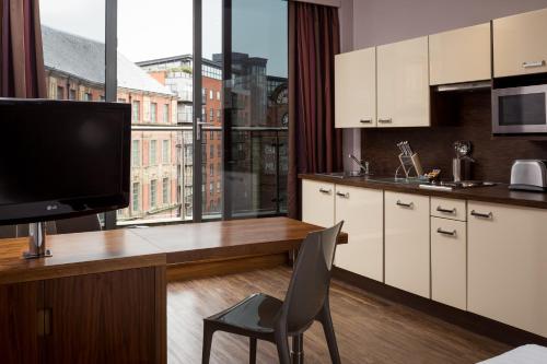 利兹利兹市罗姆兹酒店的厨房配有电视和桌椅