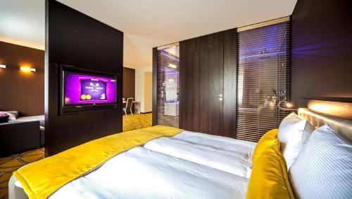 Domasław伊柯丽斯酒店的卧室配有一张大床,墙上配有电视