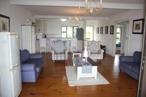 Ponta MalanganeAlfies House的一间带蓝色沙发的客厅和一间厨房
