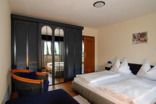 埃尔毛Haus Hammerer的一间卧室配有一张床、一把椅子和镜子