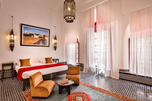 非斯本苏达摩洛哥传统庭院住宅的酒店客房,配有一张床和两把椅子