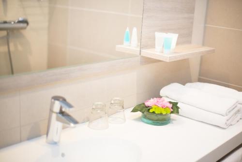 玛丽港潘美酒店的浴室水槽,配有花瓶和毛巾