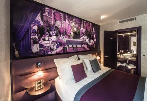 巴黎艾丽赛金碧酒店的卧室配有一张大床上方的大画