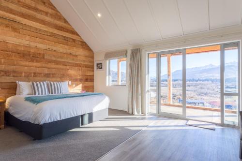 皇后镇沙特欧瓦乡村木屋的一间卧室设有一张床和大窗户
