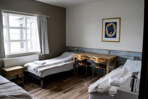 布扎达吕尔达拉科特布达代尔酒店的客房设有两张床、一张桌子和一扇窗户。