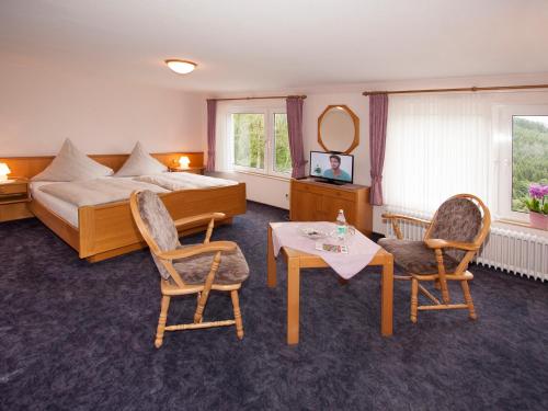 施马伦贝格德罗斯特-沃格特膳食公寓旅馆的酒店客房带一张床、一张桌子和椅子