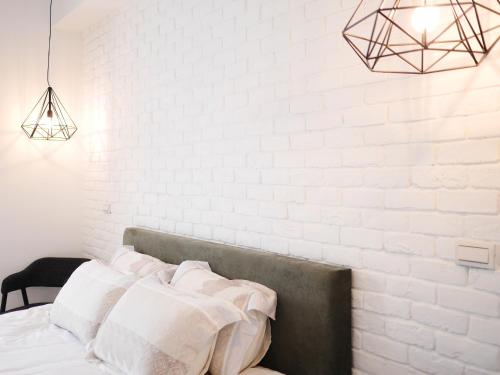员山乡厝味民宿的卧室拥有白色的墙壁,配有一张带白色枕头的床。