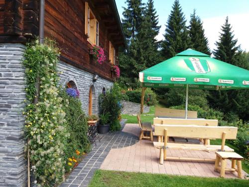 小莫拉夫卡Chata U Vlastíka的一个带绿伞和长凳的庭院