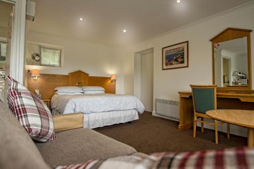 Gosfield伽斯菲尔德湖畔安尼克斯汽车旅馆的配有一张床和一张书桌的酒店客房