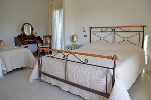 圣玛丽亚纳瓦雷B&B Cara'a mare的一间卧室配有一张床、镜子和一张桌子