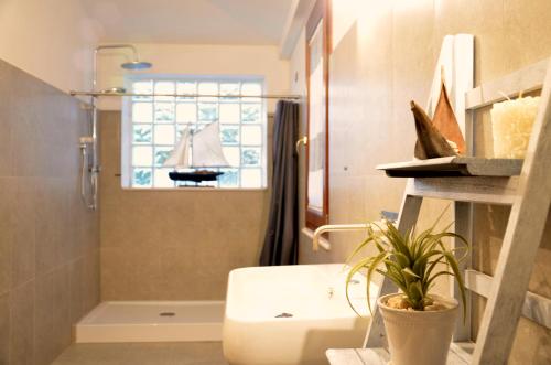 圣玛丽亚纳瓦雷B&B Cara'a mare的一间带水槽和淋浴的浴室以及窗户。