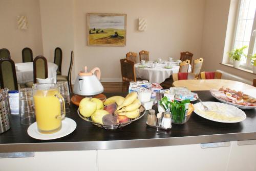 汉诺威德意志豪斯酒店的一张桌子,上面放着一碗水果和一壶橙汁
