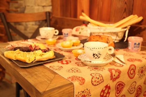布吕松Mi Casa Tu Casa的桌子,上面有桌布,上面有食物和杯子