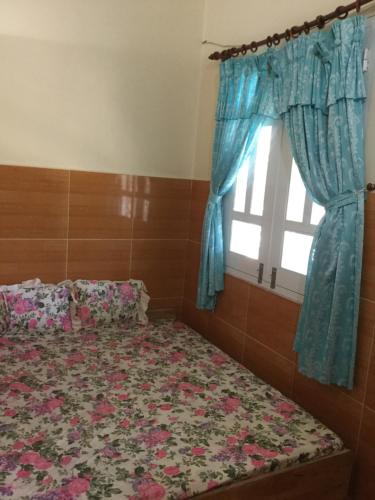 潘郎Nhu Y Guesthouse的一间卧室设有一张床和一个窗口