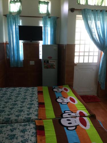 潘郎Nhu Y Guesthouse的卧室配有带猫科动物毛毯的床。