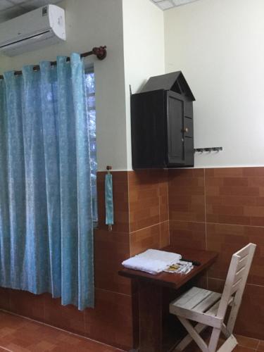 潘郎Nhu Y Guesthouse的一间设有桌子、电视和桌椅的房间