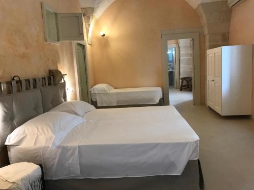 库特罗菲安诺Tenuta Castelle的一间卧室配有两张床和一台冰箱
