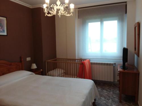 波多诺伏巴罗萨公寓的一间卧室设有一张床、一个窗口和一台电视