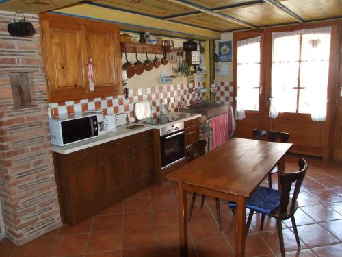 Triembach-au-Val“维涅隆”民宿的厨房配有木制橱柜、桌子和桌椅