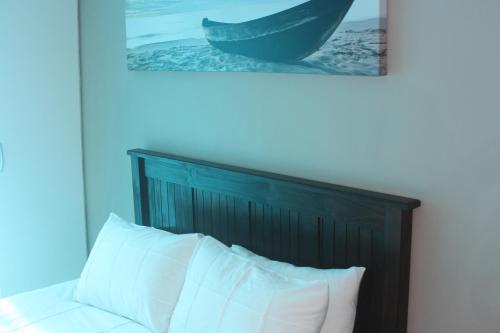 Sea ViewOcean Sunset的一张带木制床头板的床,上面有一张图画