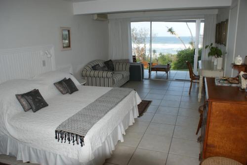维德尼斯海滩粉红小屋旅馆的一间卧室设有一张床和一间客厅。