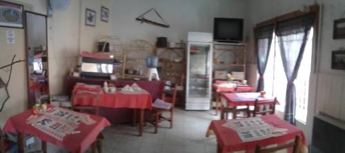 里奥夸尔托Residencial Marluc的客厅配有红色桌椅和电视