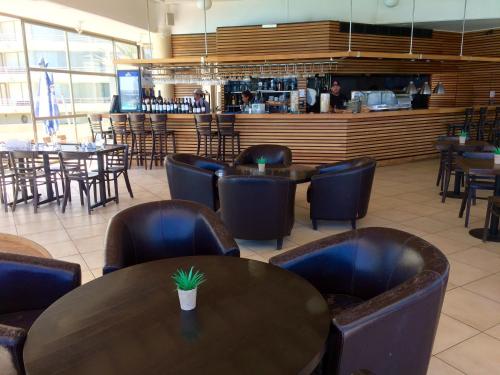 阿尔加罗沃San Alfonso del Mar Resort的一间带桌椅的餐厅和一间酒吧