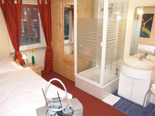 汉诺威德意志豪斯酒店的一间卧室配有一张床、淋浴和盥洗盆