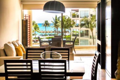 普拉亚卡门The Elements Oceanfront & Beachside Condo Hotel的一间带桌椅的用餐室