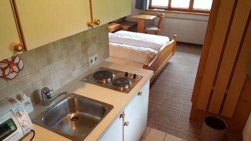 SibratsgfällGasthof Hotel IFENBLICK的一个带水槽和床的小厨房