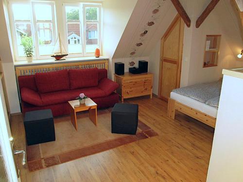 格拉尔-米里茨“Haus am Küstenwald” Ferienwohnungen的客厅配有红色的沙发和床。