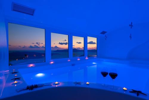 费拉费拉深蓝套房别墅的蓝色客房设有浴缸和窗户。