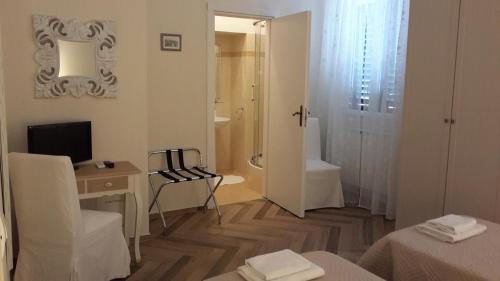 佛罗伦萨塔贝纳克罗住宿加早餐旅馆的白色的客房设有书桌、电视和浴室。