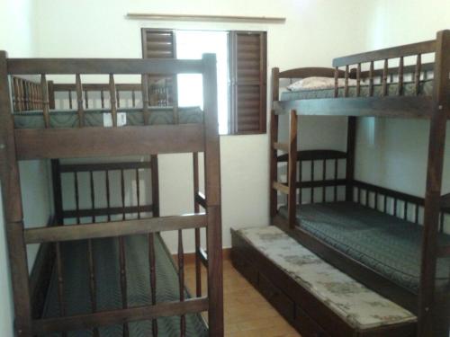 卡拉瓜塔图巴Casa em Caraguatatuba的一间房间,设有三张双层床