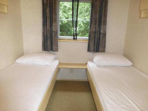 HezingenVakantieverblijf Springendalsebeek的小型客房 - 带2张床和窗户