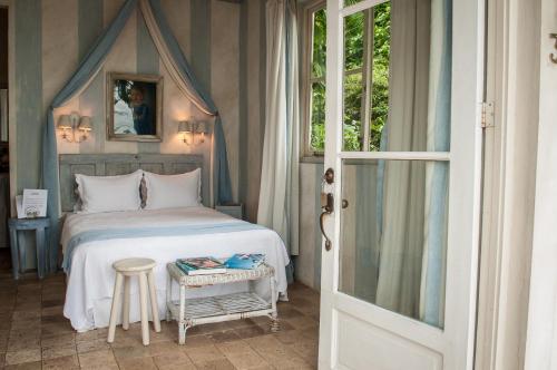 塔沃加卡普里科萨别墅的一间卧室配有一张床和一张桌子及凳子